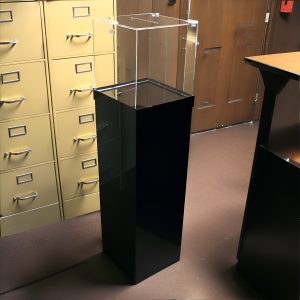 clear donation box on black pedestal